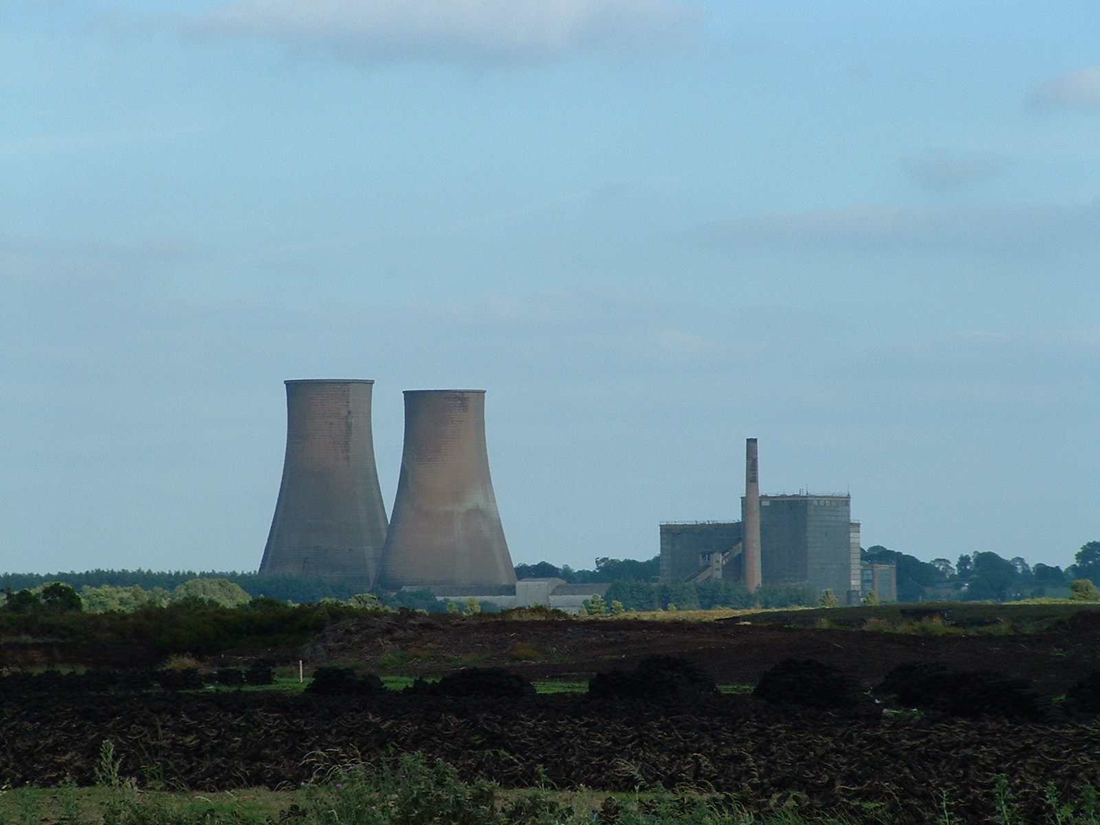View of Rhode Generating Station with cooling towers, station buildings and surrounding bogland in the foreground.
