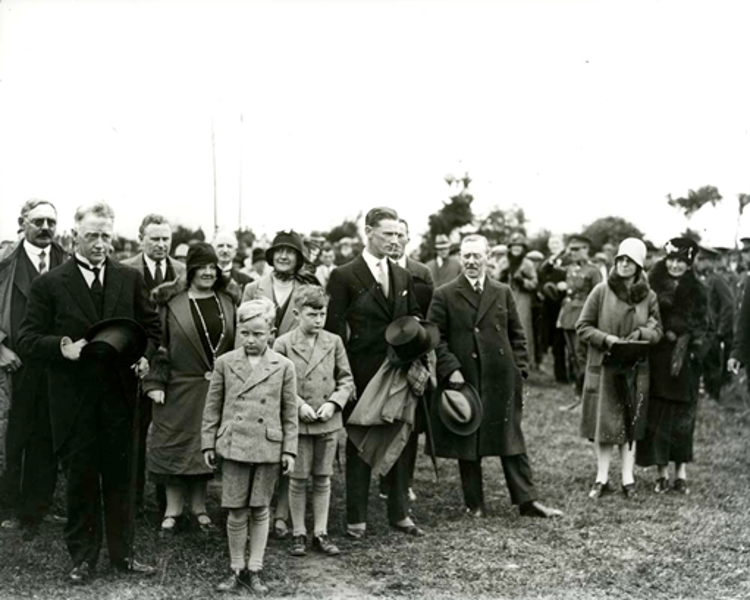 Historic photograph of a crowd of adults and children gathered outdoors at an official event associated with the early development of ESB.