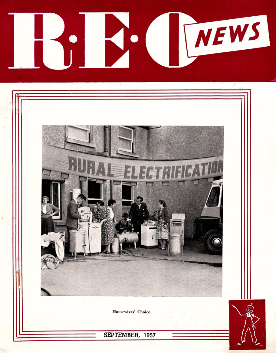 Cover of the REO News publication dated September 1957. The cover features a black-and-white photograph of a rural electrification demonstration, with people viewing household electrical appliances beneath a banner reading “RURAL ELECTRIFICATION.”
