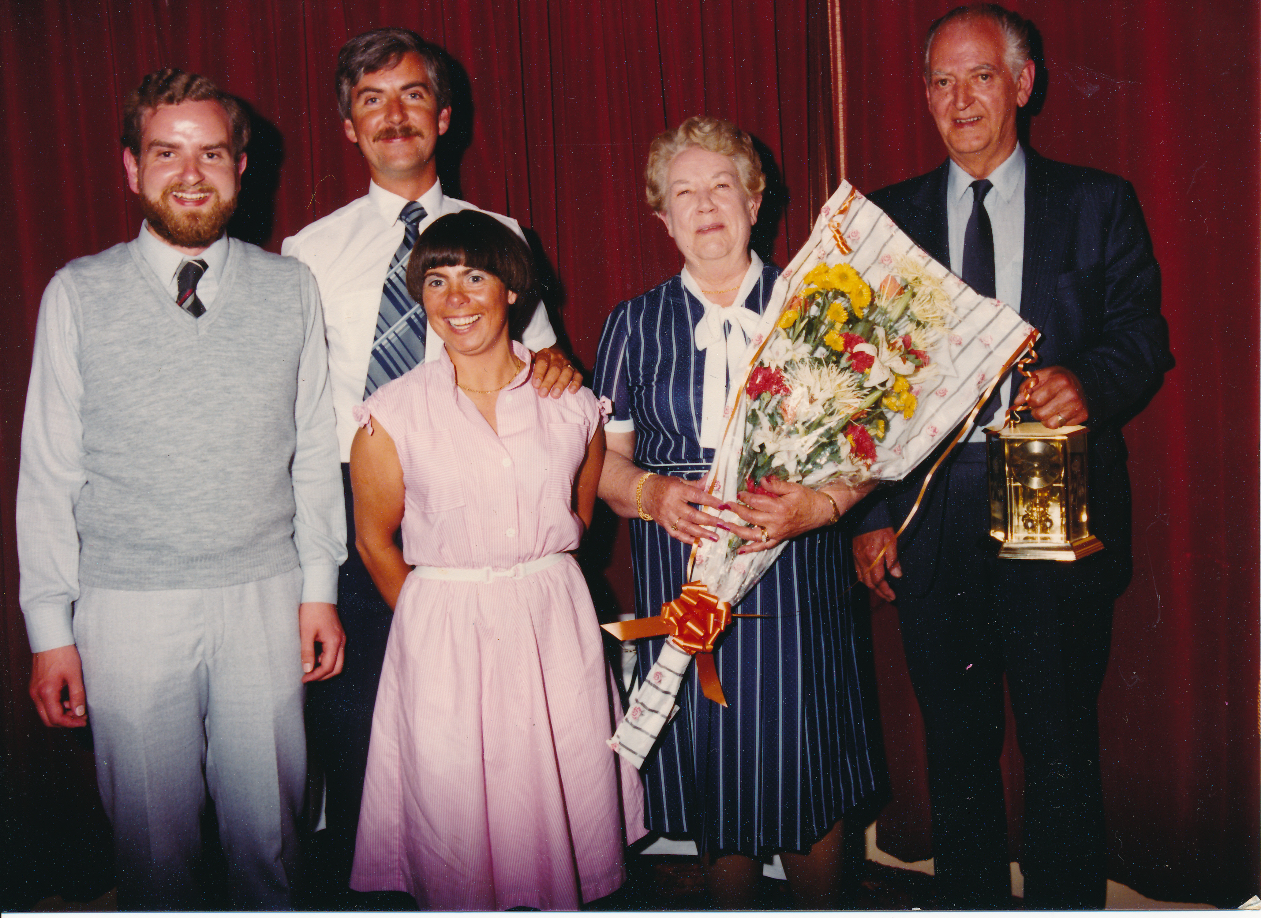 Colour photograph from an ESB retirement celebration, showing Jerry Corbett standing with family members beside presentation gifts, including a bouquet of flowers.