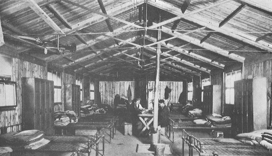 Sleeping area with two men and various beds on either side.